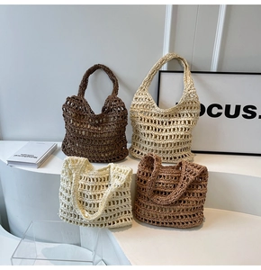 Close-up of three woven mesh tote bags in brown and cream on a minimalist white stand