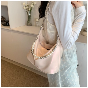 Dettaglio borsa hobo rosa chiaro con catena d'argento e tracolla decorativa con perle