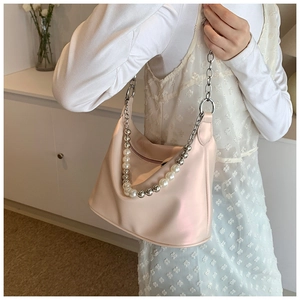 Dettaglio della borsa a mezzaluna in pelle PU rosa con tracolla di perle e catena argento