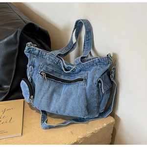 Fashionable washed blue denim tote bag with multi-pocket utility design and long strap