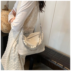 Dettaglio borsa a tracolla in pelle PU beige con doppie catene decorative in perle e metallo