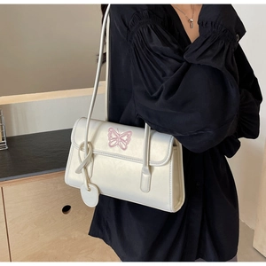 Detail of cream PU leather shoulder bag with pink butterfly embroidery and knotted strap