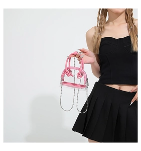 Détail d'un mini sac à main rose transparent avec corps en PVC et chaîne argentée