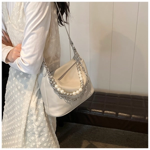 Dettaglio della borsa a spalla in pelle PU crema con perle e catene argentate decorative
