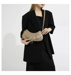 Detail of khaki crescent crossbody bag featuring silver buckles and ring on a matte PU finish