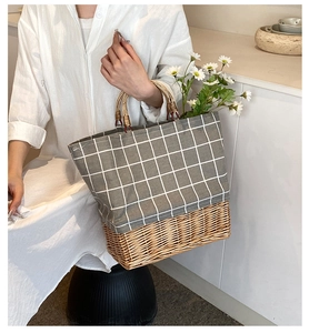 Close-up of a canvas and straw patchwork tote bag with bamboo handles on a white table