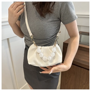 Close-up of cream pleated cloud bag with transparent bead chain and adjustable strap