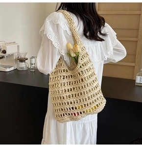 Detail of hand-woven hollow straw tote bag with flowers in a cozy cafe setting