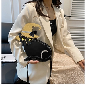 Detailed view of black cat-shaped crossbody bag with gold wizard hat lid on a model