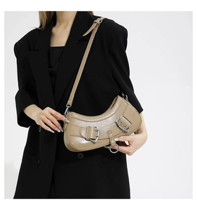 Detailed shot of khaki PU crescent bag with silver buckles and retro cracked texture