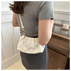White ruched cloud bag with marble acrylic bead handle shown in a lifestyle setting
