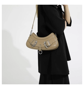 Detail of khaki PU leather half-moon shoulder bag with decorative straps and silver ring
