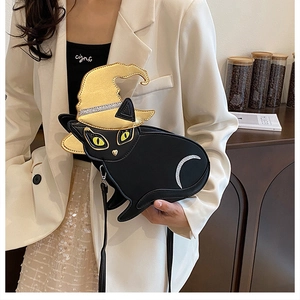 Detail of a black cat-shaped crossbody bag with a gold wizard hat and sequin accents