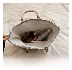 Top view of spacious grey checkered tote bag showing interior storage for umbrella and cosmetics