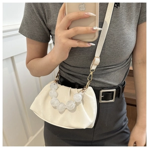 Detail of off-white pleated cloud bag with elegant marble bead handle and golden hardware