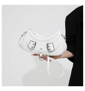 Detail of white PU crescent bag with silver buckles and smooth faux leather texture