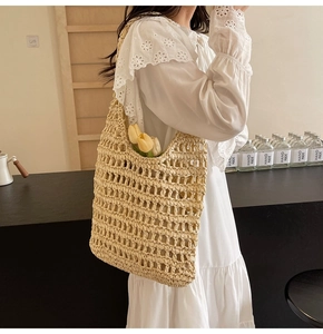 Detail of hollow-out woven texture on an ivory straw shoulder bag for summer