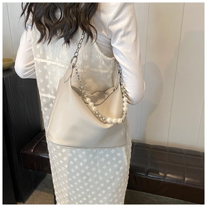 Dettaglio borsa a tracolla in pelle PU crema con catena decorativa di perle e metallo