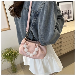 Detail of pink pleated cloud bag with large marble bead handle and thin shoulder strap