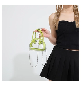 Détail du mini sac transparent en PVC avec poignée en cuir vert néon et bandoulière