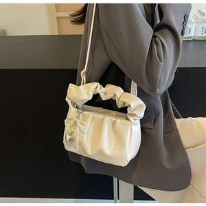 Detail of cream PU cloud bag with ruched texture and pearl heart charm accessory