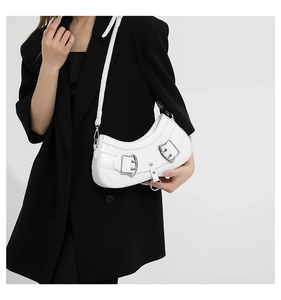 Close-up of a white crescent shoulder bag with silver hardware and glossy leather