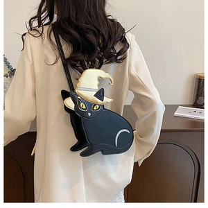 Detail view of Halloween black cat crossbody bag with wizard hat on a female model