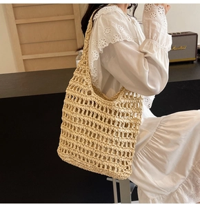 Close-up of beige woven straw tote bag with large hollow mesh design and natural texture
