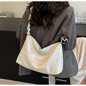Detail of white PU leather crossbody bag with pink bow and fashion embroidery