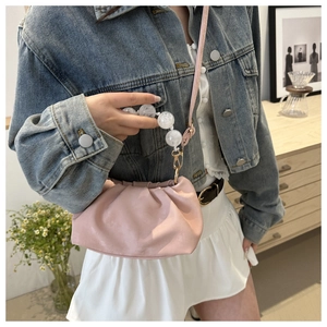 Pink cloud dumpling bag with acrylic bead chain handle shown on a model with denim jacket