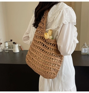 Detail of hand-woven hollow straw tote bag in brown with lightweight mesh texture