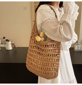 Detail showing the large-hole mesh texture and handmade straw weaving of the tote bag