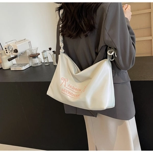 Detail of white PU leather hobo bag with pink bow embroidery and pleated strap in cafe