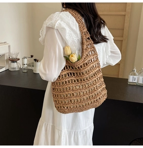 Close-up of stylish brown straw handbag with hollow woven pattern for casual vacation look