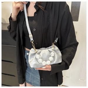 Detail of silver cloud crossbody bag with marble beaded handle and pleated texture