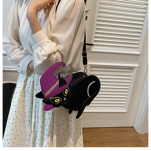 Detail of cartoon cat crossbody bag in black PU leather with witch hat worn by model