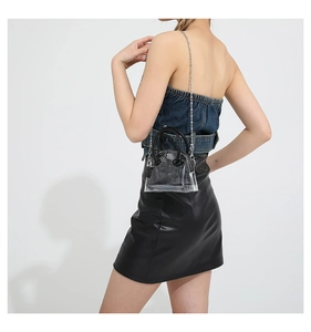 Sac à main demi-lune en PVC transparent avec poignées noires porté par le modèle