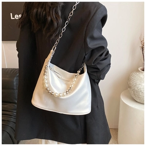Borsa hobo in raso bianco con manico di perle e catena d'argento sulla spalla del modello