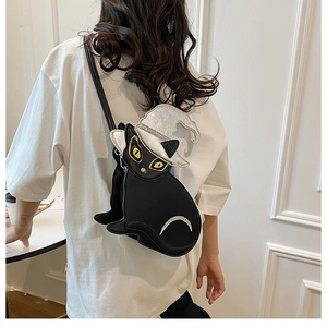Close-up of a 2024 cartoon black cat crossbody bag with a silver wizard hat worn by a model