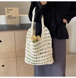 Detail of white crochet straw tote bag with floral accents in a French vintage setting