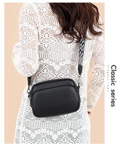 Detail of black lychee grain camera bag with double zippers and wavy jacquard strap