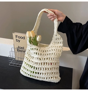 Detailed macro view of cream-colored woven straw handbag with hollow mesh texture