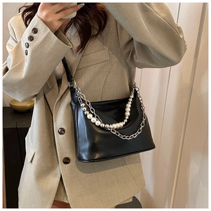 Dettaglio borsa sottobraccio in pelle PU nera con catene di perle e metallo argento