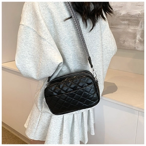 Detailed view of black quilted PU crossbody bag with geometric pattern wide shoulder strap