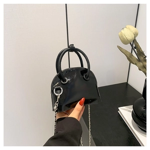 Mini sac à main 2024 en cuir PU noir avec chaîne argentée présenté dans un décor chic