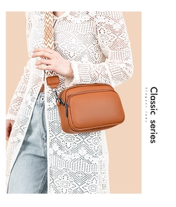 Brown lychee leather crossbody bag with double zippers and geometric woven shoulder strap