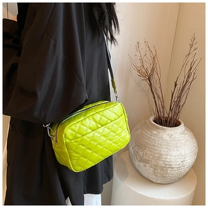 Detail showing fluorescent yellow quilted PU leather crossbody bag with silver hardware