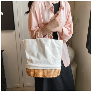 Detail of hand-woven rattan base and canvas fabric on stylish tote bag with wooden handle