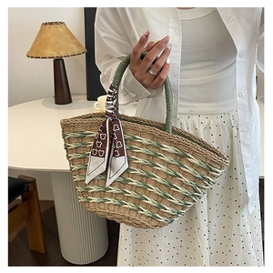 Close-up of green and beige woven texture on handbag with decorative bear print scarf detail