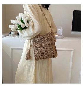 Detail of hand-woven crossbody bag featuring wood bead tassel and textured wave pattern